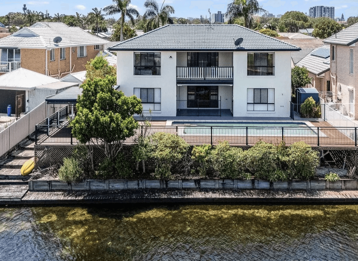 Aerial view of a house with a pool and surrounding greenery.