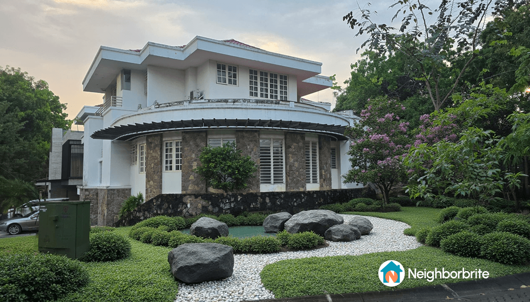 A beautifully landscaped garden with rocks, greenery, and a modern house.