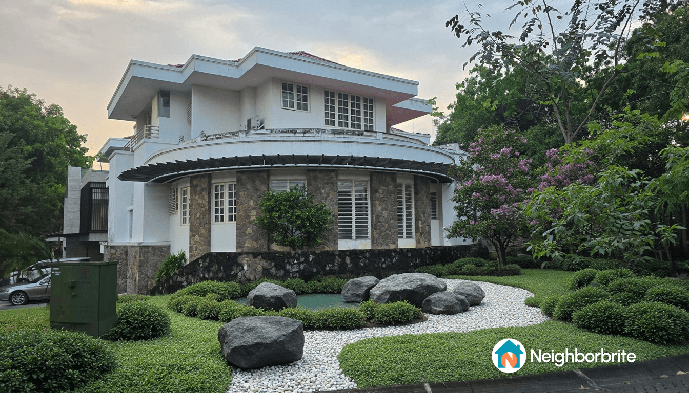 A beautifully landscaped garden with rocks, greenery, and a modern house.
