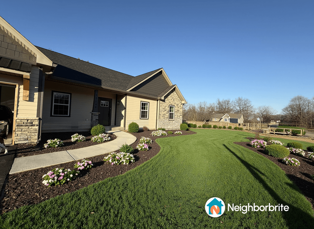 Front yard with flowers and shrubs, suggesting hydrangeas and evergreens.