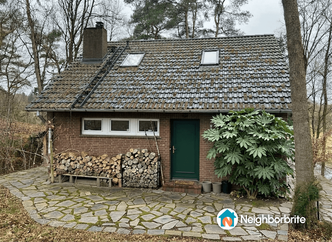 A house with a green door and stacked firewood, suggesting a garden update.