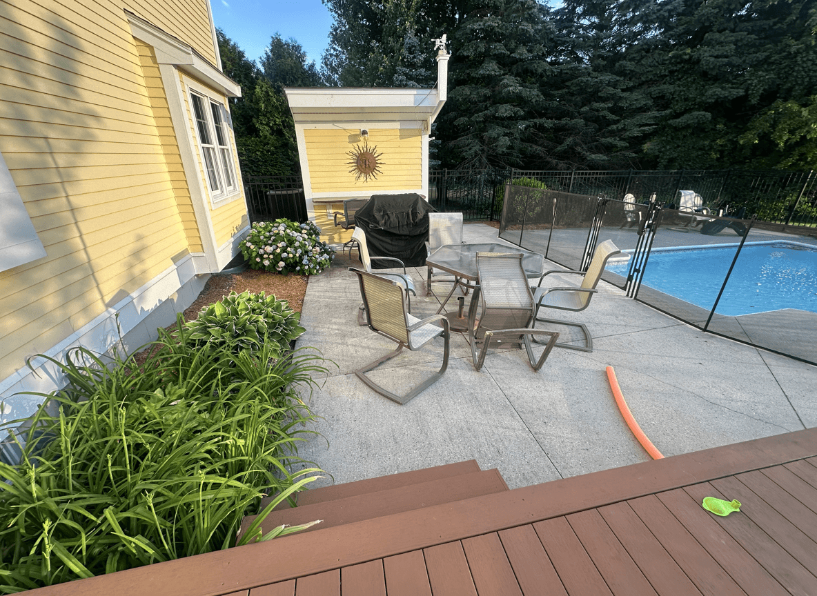 A west facing plant bed with patio furniture and pool area.
