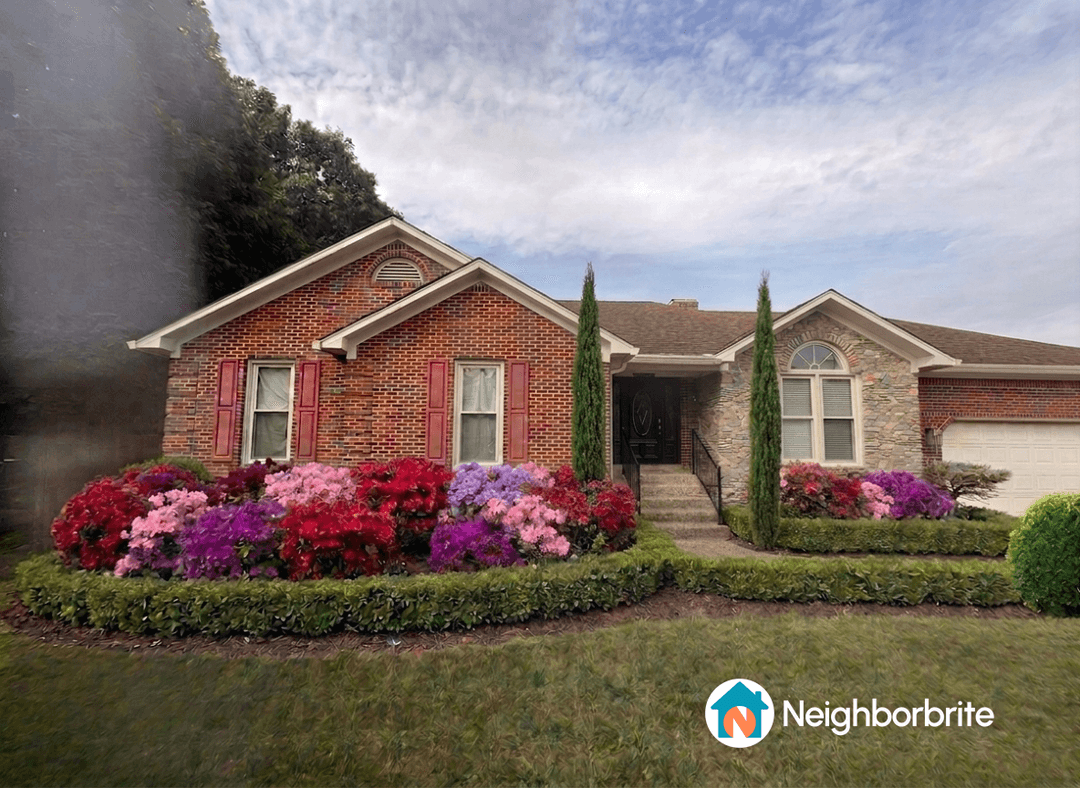 A beautiful home with colorful flower beds and shrubs.