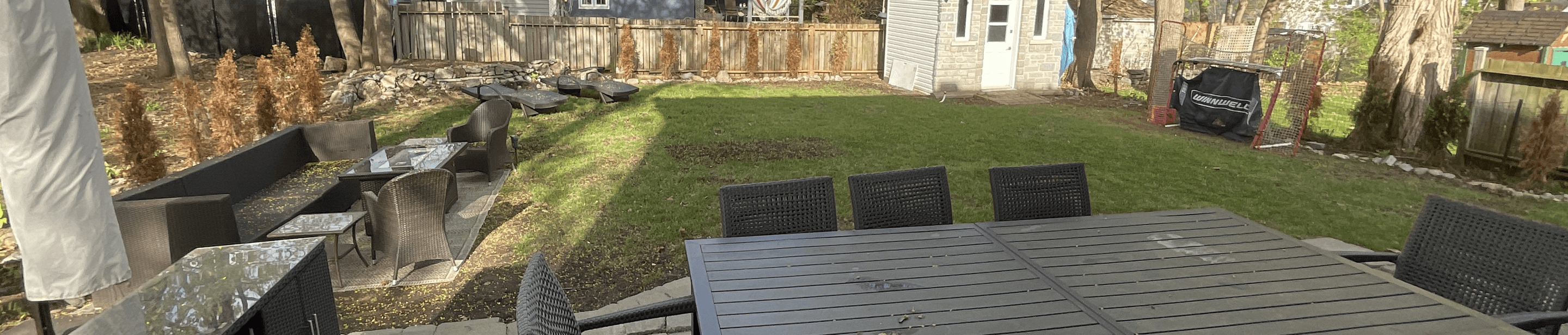 A spacious backyard with seating areas and a shed.