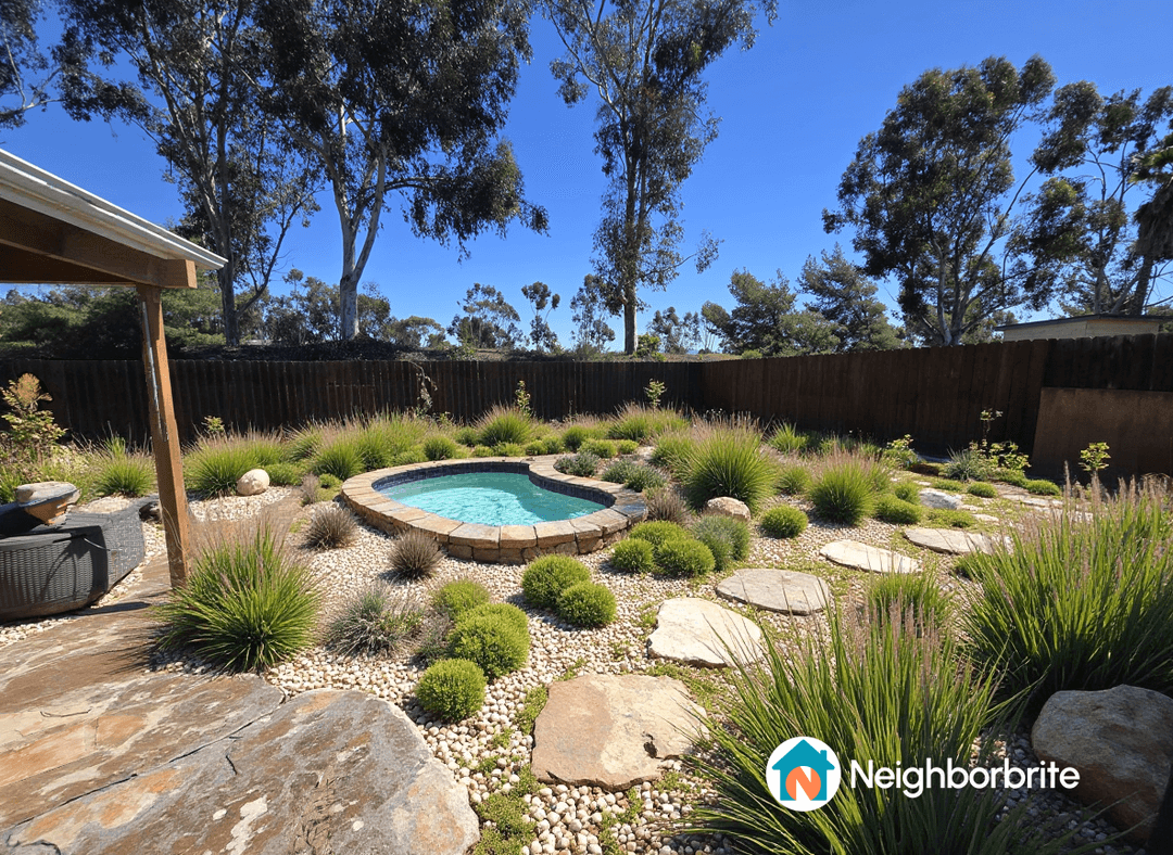 A landscaped yard featuring a small pool surrounded by plants and stones.