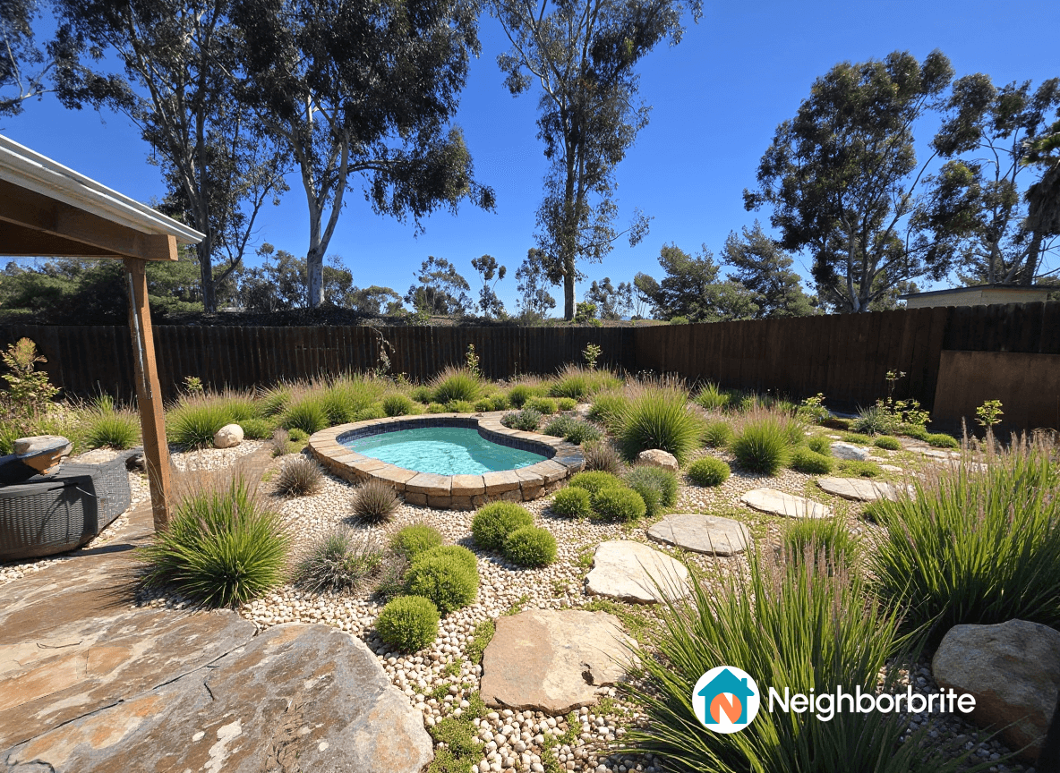 A landscaped yard featuring a small pool surrounded by plants and stones.