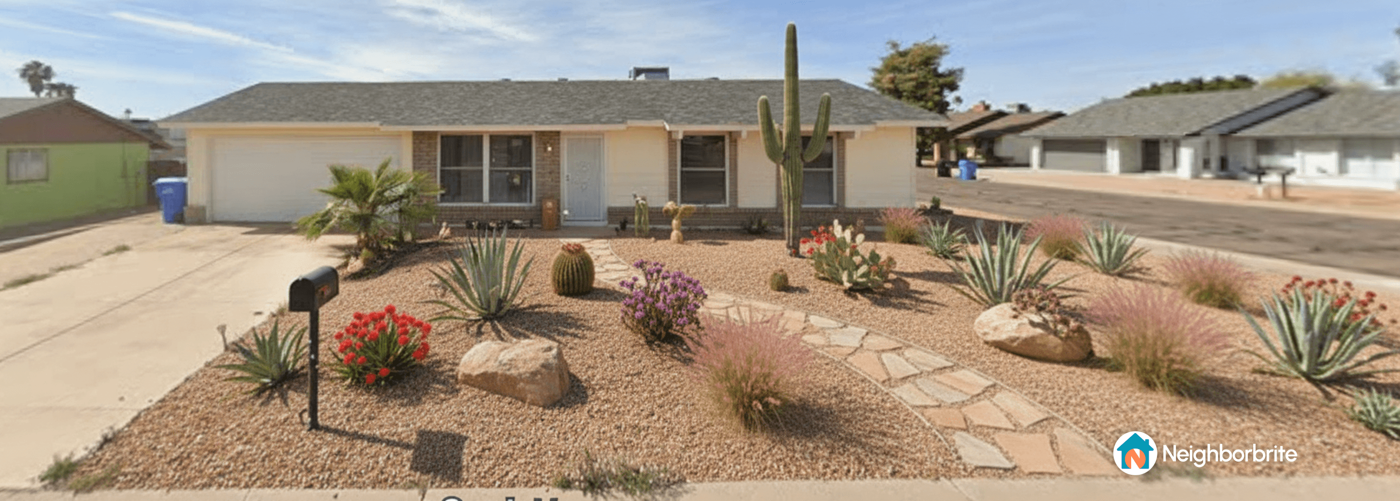 Front yard with desert landscaping, featuring cacti and colorful plants.