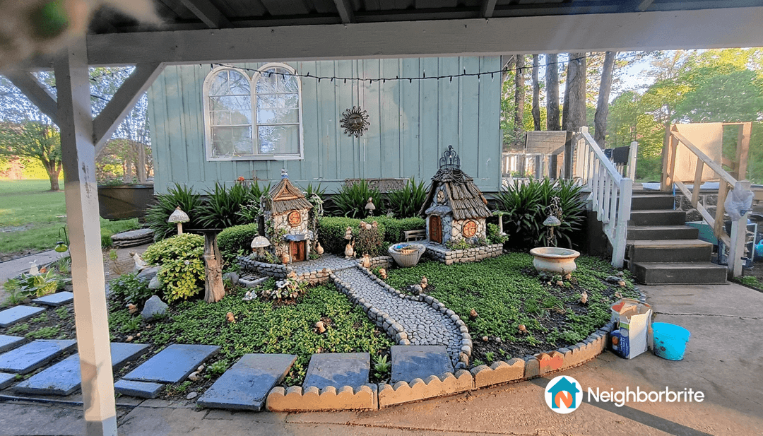 A whimsical garden with stone paths and miniature houses.