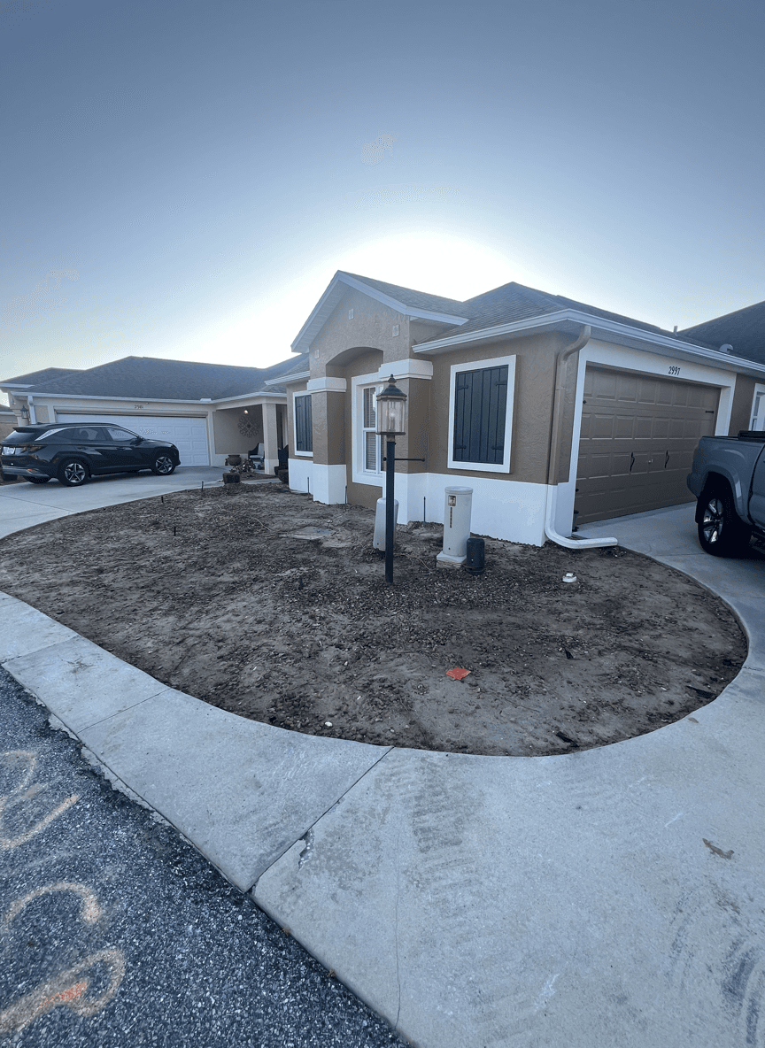 A front yard with a lamp post and bare soil, planning for landscaping.