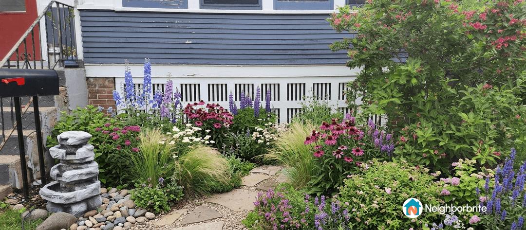 Colorful flowers and a stone fountain in a lovely garden setting.