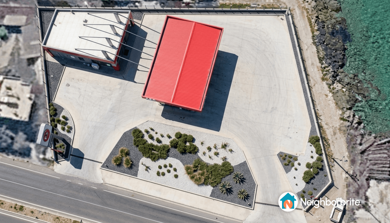 Aerial view of a modern building with red roof and landscaped area.