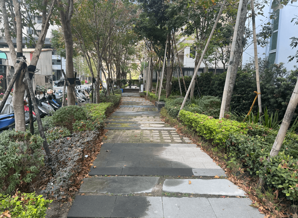 A serene pathway lined with trees and greenery, showcasing a peaceful outdoor space.