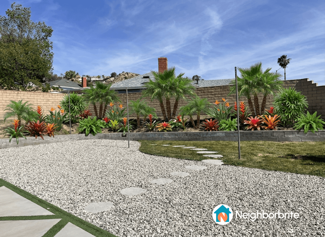 A landscaped yard featuring vibrant plants and gravel pathways.