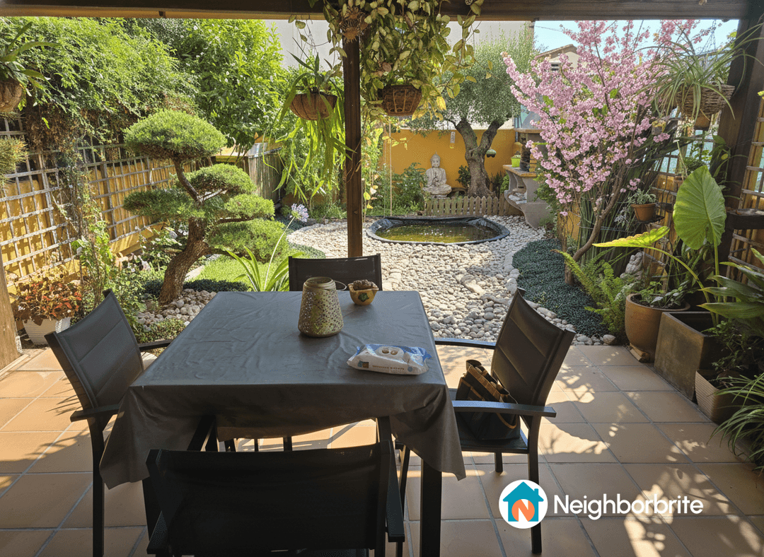 A serene garden view featuring a pond, bonsai tree, and lush plants.