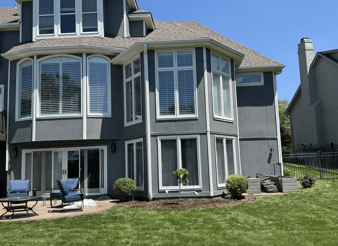 Home exterior featuring a newly planted Fire Light hydrangea tree in front of bay windows.