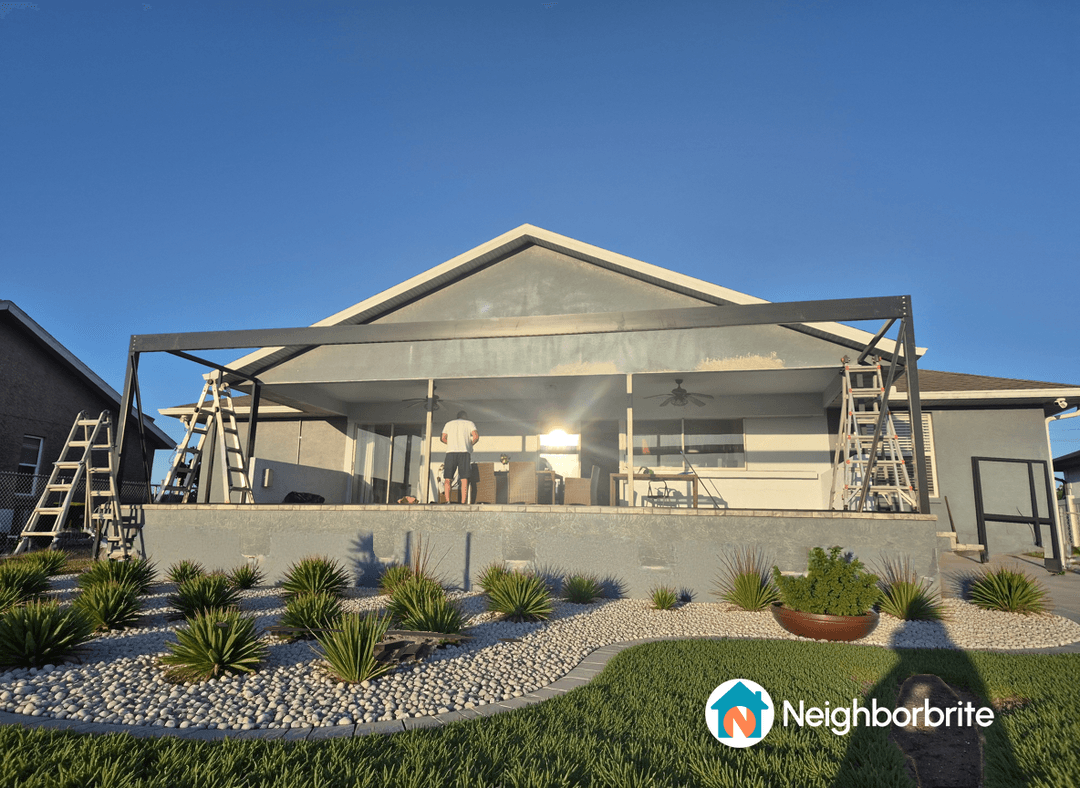 A home with a patio under construction and landscaping featuring small plants.