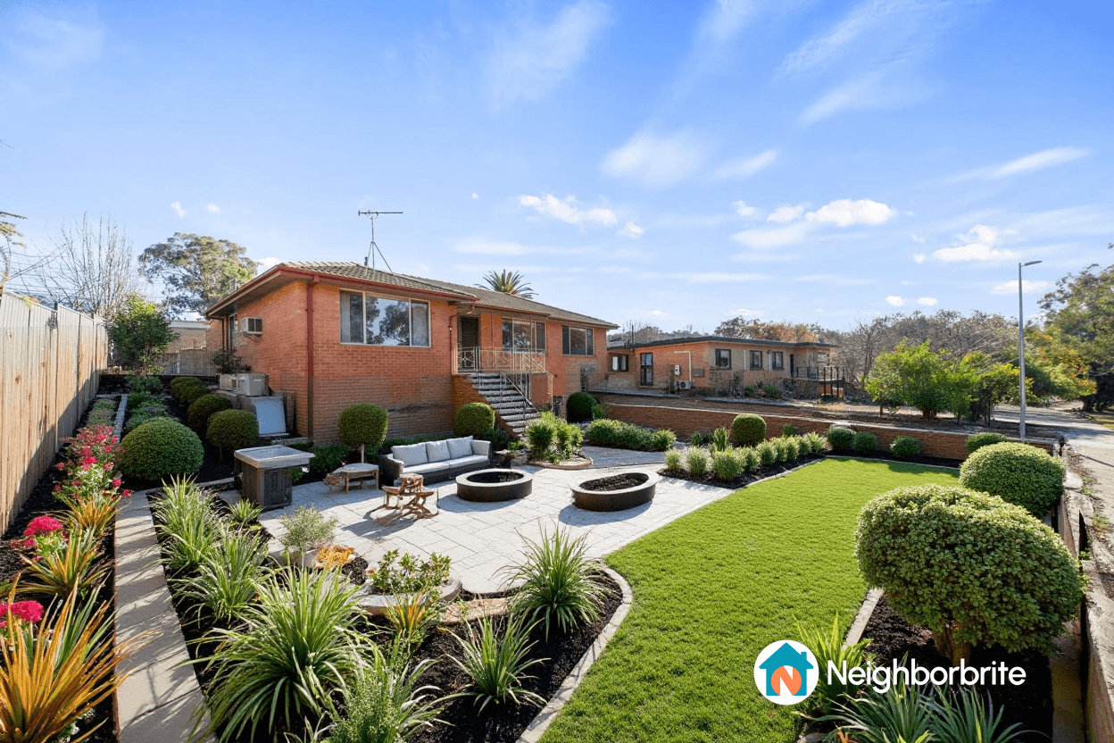 A beautifully landscaped yard featuring plants, seating, and fire pits.
