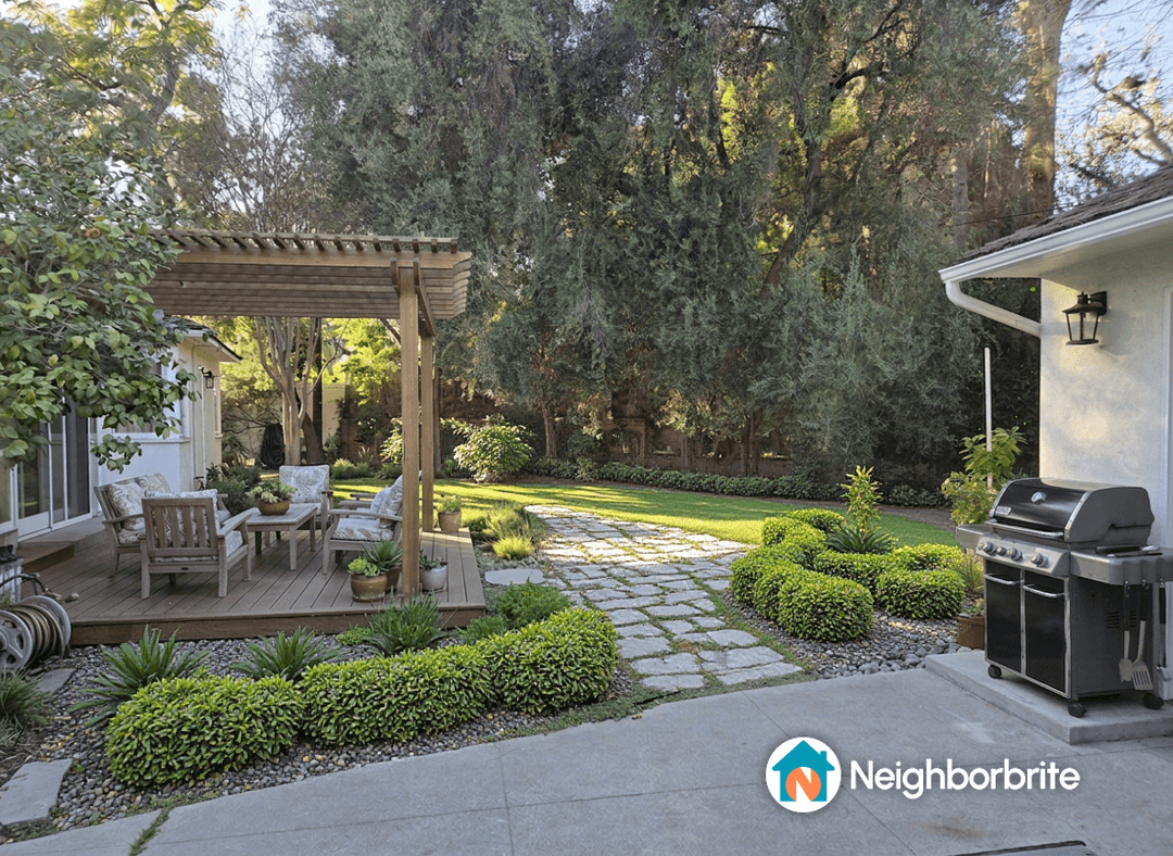 Yard with patio, greenery, and a barbecue grill on the right.