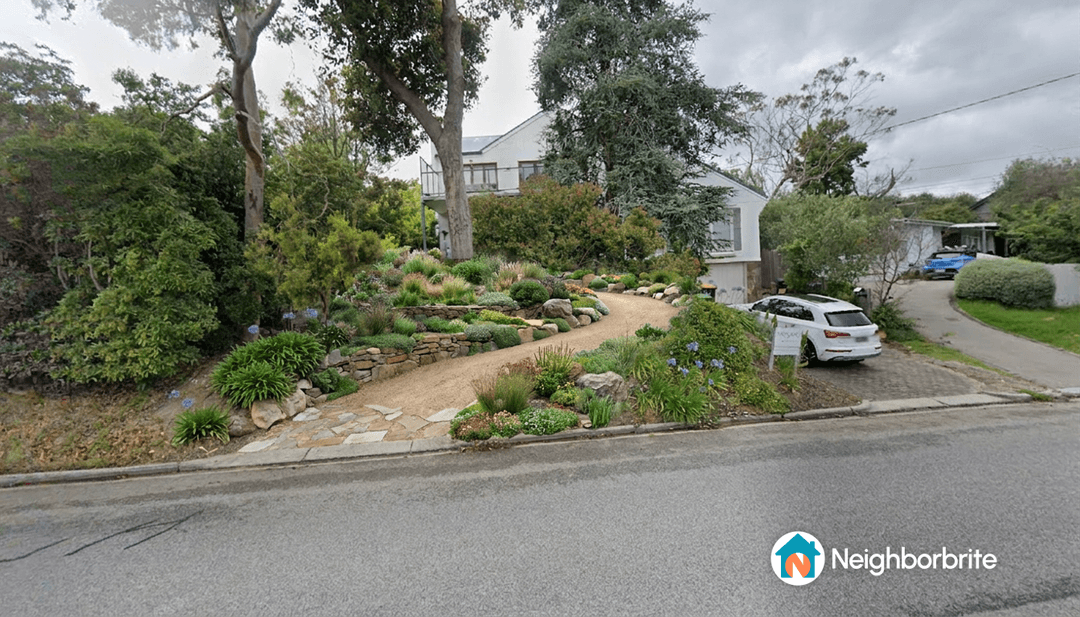 A landscaped driveway with trees, showing a safe exit onto the road.