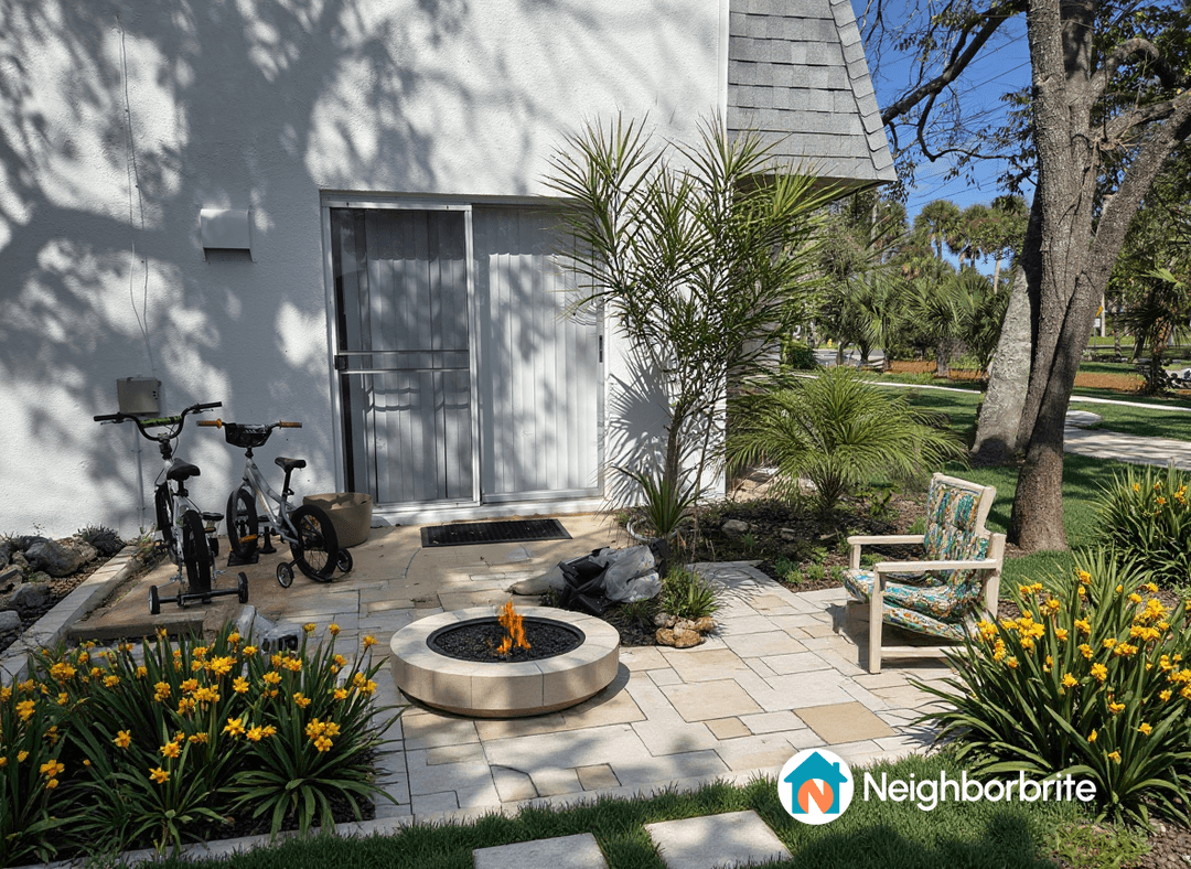 A patio area with a fire pit, flowers, and bikes.