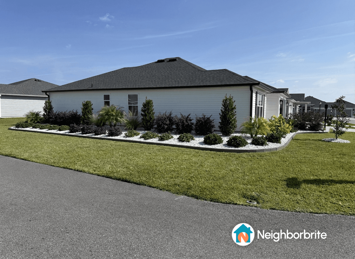 A landscaped yard with colorful plants and bushes along a house.