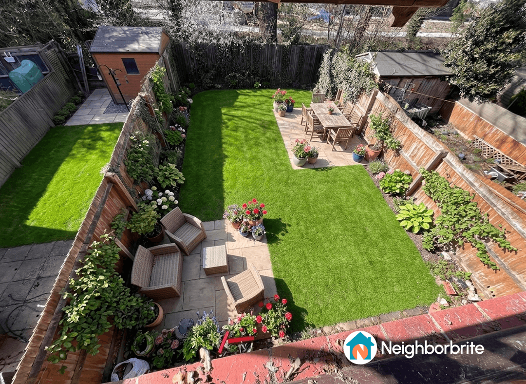Aerial view of a garden with dining and lounge areas, flowers, and grass.