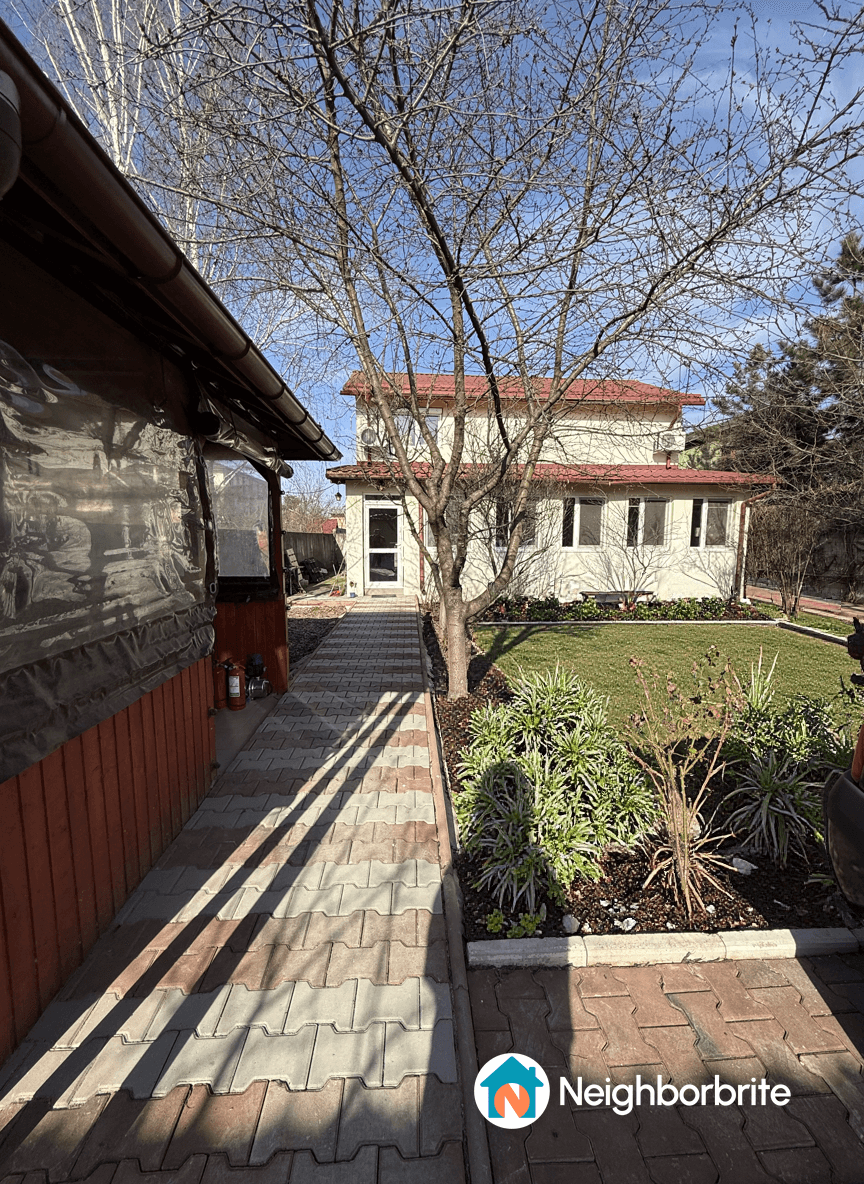Pathway with warm LED lights, uplights on trees, and house facade.